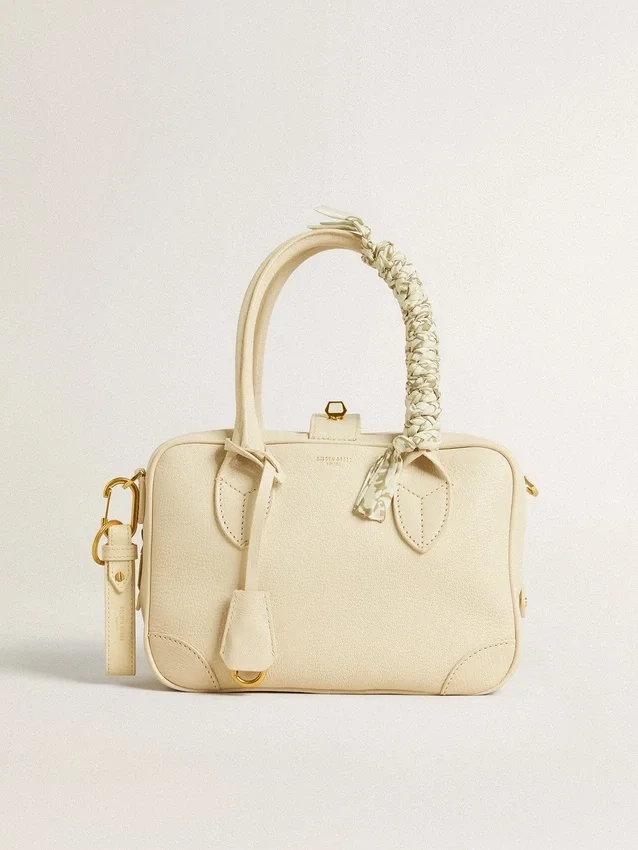 Butter-colored braided fabric charm with brass chain